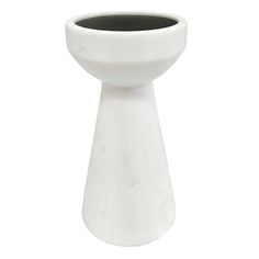 a white vase sitting on top of a table