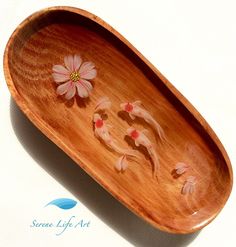 an oval wooden tray with flowers painted on the bottom and sides, sitting on a white surface