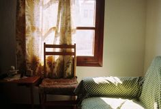 a chair sitting in front of a window next to a desk