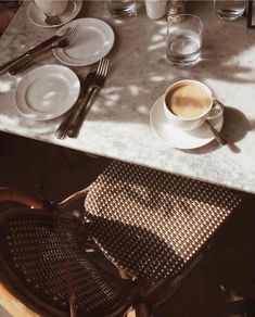 a table with plates, cups and utensils on it