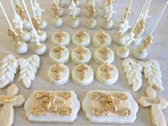 a table topped with lots of cupcakes covered in white frosting and gold decorations