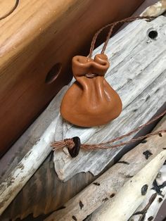 a wooden box with a bag on top of it next to some branches and wood