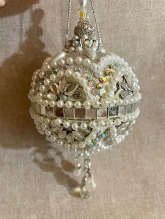 an ornament with pearls and jewels hanging on a wall