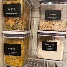 three plastic containers filled with food sitting on top of a metal shelf in a refrigerator