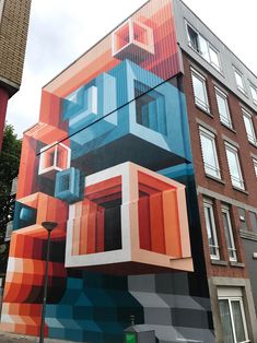 a tall building with many different colored boxes on it's face and windows painted on the side