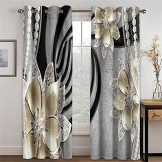 the curtains in this room are decorated with black and white floral design, along with silver accents