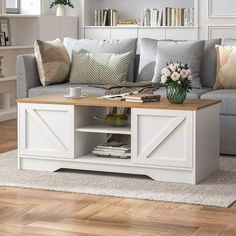 a living room with a gray couch and white coffee table in front of a window