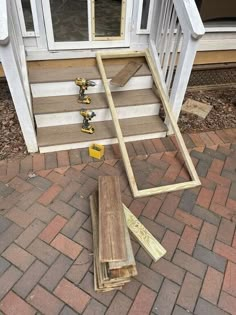 some tools are laying on the ground near a door and steps that have been made out of wood