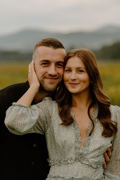 a man and woman standing next to each other in a field