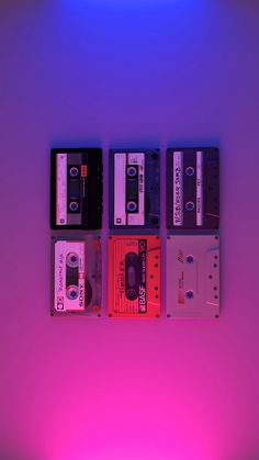 four old school cassettes are lined up against a purple background, with the light shining on them