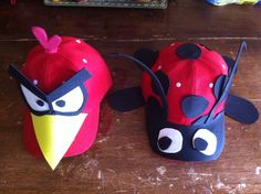 two angry birds hats sitting on top of a wooden table