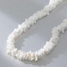 a white necklace on a gray surface