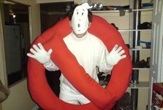 a man in a costume is standing with his arms around the body of a large red object