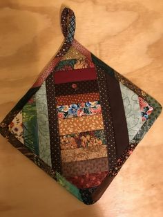 a close up of a piece of cloth on a wooden table with a tie hanging from it