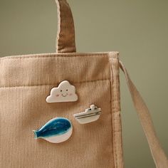 a handbag with some stickers on it and a blue cloud in the middle