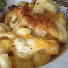 a white plate topped with macaroni and cheese next to a sandwich on a bun