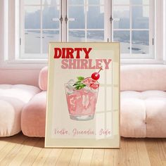 a poster with a cherry drink on it in front of a pink couch and window