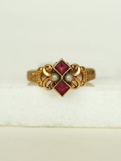 Her dainty Victorian style with gold work scrolls frame a powerful pair of Pearls and two stacked Rubies, set in a 10k gold band.

She's a fine addition to your collection.

 

 	Ladies Size 6
 	10k Yellow Gold Band
 	Two Ruby red stones, pearls
 	Arrives in gift box

Exclusively from Erin Pelicano Curated Vintage Collection. Each piece is intentionally chosen, pre owned, and ready to be loved and cherished again. sold as shown.

Shop the Curated Vintage Collection Ruby Ring Stacking, Vintage Stone Rings, Victorian Gold Jewelry, Vintage Gold Wedding Rings, Vintage Rings Antiques, Unique Engagement Rings Vintage Antiques, Vintage Promise Rings, Antique Engagement Rings Victorian, Vintage Gemstone Rings