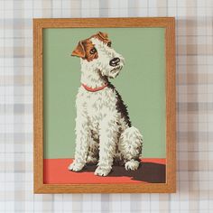 a small white and brown dog sitting in front of a green background