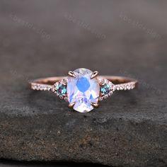 a ring with an oval shaped blue topazte surrounded by three smaller round diamonds