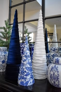 several blue and white vases are sitting on a shelf in front of a mirror