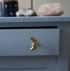 a close up of a drawer with a moon on it and other items in the background