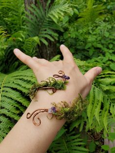 Step into a world of enchantment and healing with this whimsical fairy-inspired jewelry set. Handcrafted with love and meticulous attention to detail, our copper woven bracelet adorned with amethyst and moss is the perfect accessory for anyone seeking a touch of magic in their lives. Complementing the bracelet, our charming pinecone earrings with moss add a delightful, natural touch to your ensemble. Note: Made for 3" wide wrist **Healing Properties - **Copper Known for its healing properties, c Forest Fairy Accessories, Fairy Core Accessories, Druid Cosplay, Fairy Birthday Themes, Pinecone Earrings, Fairy Bracelet, Moss Jewelry, Fairy Bracelets, Fairy Pouch