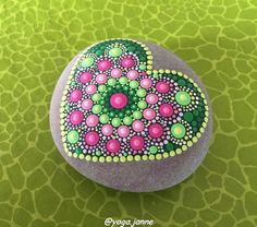 a painted rock sitting on top of a green surface