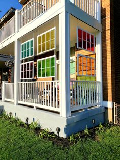 a white house with multicolored windows and balconies on the front porch