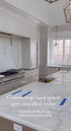 a kitchen with white cabinets and marble counter tops that has the words, countertop backsplash gets installed today