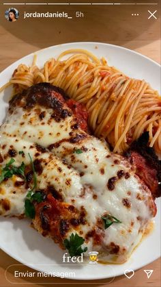 a white plate topped with pasta and meat covered in sauce