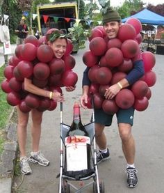 two people with balloons on their heads are standing next to a stroller