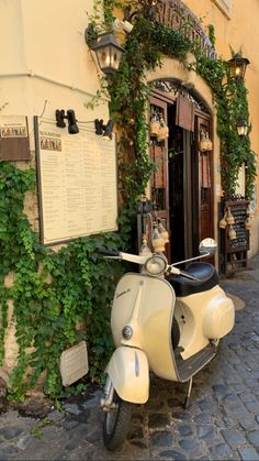 a scooter parked in front of a building with ivy growing up the side