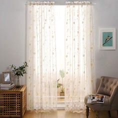 a living room with a chair, window and pictures on the wall