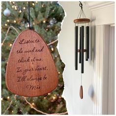 a wooden ornament hanging from the side of a tree next to a christmas tree