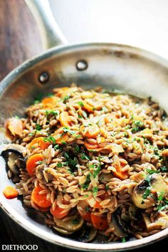 a pan filled with pasta and vegetables on top of a wooden table