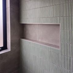 there is a window in the corner of this bathroom that looks like it's made out of cement