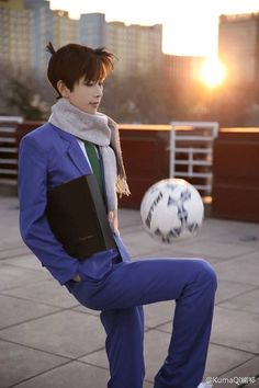 a person is posing for a picture with a soccer ball in the background