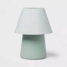 a light green table lamp with a white shade on the top and bottom part of it