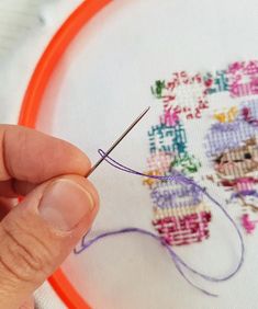 a person is stitching on a piece of fabric