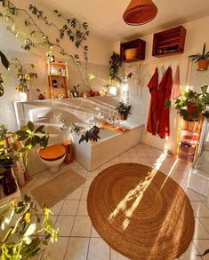 a bath room with a tub a toilet and plants