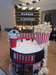 a cake made to look like a bucket of popcorn and some movie posters on it