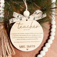 a teacher ornament hanging from a tree