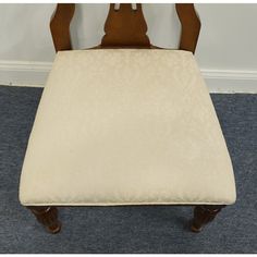 a wooden chair with a white cushion on it