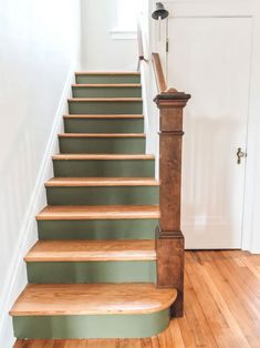 a set of stairs leading up to a door in a room with hard wood floors