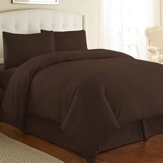 a bed with brown sheets and pillows in a room