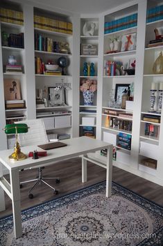 a white desk sitting in front of a book shelf filled with books