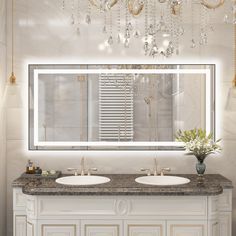 a bathroom vanity with two sinks and a large mirror above it, surrounded by chandeliers