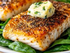 grilled fish topped with butter and spinach leaves