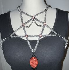 This pentagram harness is hand-knotted with great dedication and is an absolute eye-catcher for every occasion. It is adjustable in size and can therefore be worn in different ways. The doll on which the top hangs has a clothing size of 38/40 (DE) and B-C cups. Thanks to the adjustable straps, the top can be worn in clothing sizes between 34-42/A-D cups (DE). If necessary, the straps can be lengthened or shortened. The snake pendant can also be exchanged, please write to me about this so that we Pentagram Harness, Chainmail Clothing, Chain Harness, Chainmail Jewelry, Handmade Chain, Fairy Jewelry, Chain Maille Jewelry, Snake Pendant, Diy Wire Jewelry